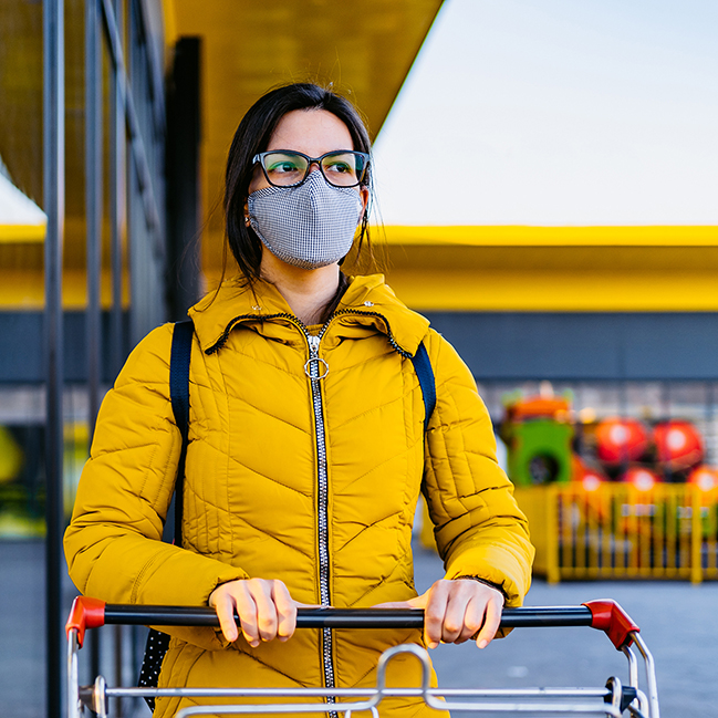 woman wearing a mask and pushing a shopping cart